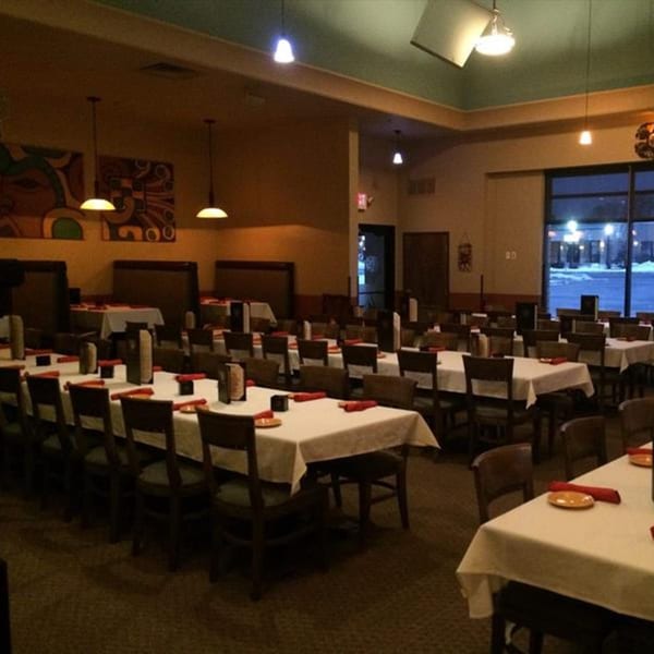 Osorio's Latin Fusion dining room with set tables, booths, and large windows at night.