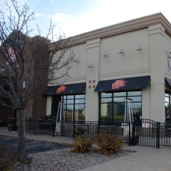 Exterior of Osorio's Latin Fusion restaurant with black awnings, outdoor patio, and bare trees.