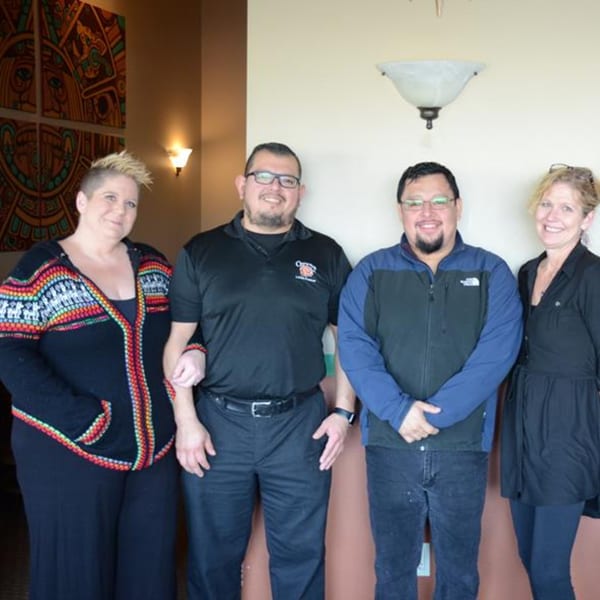 Four smiling Osorio's Latin Fusion staff members, two men and two women, standing together.